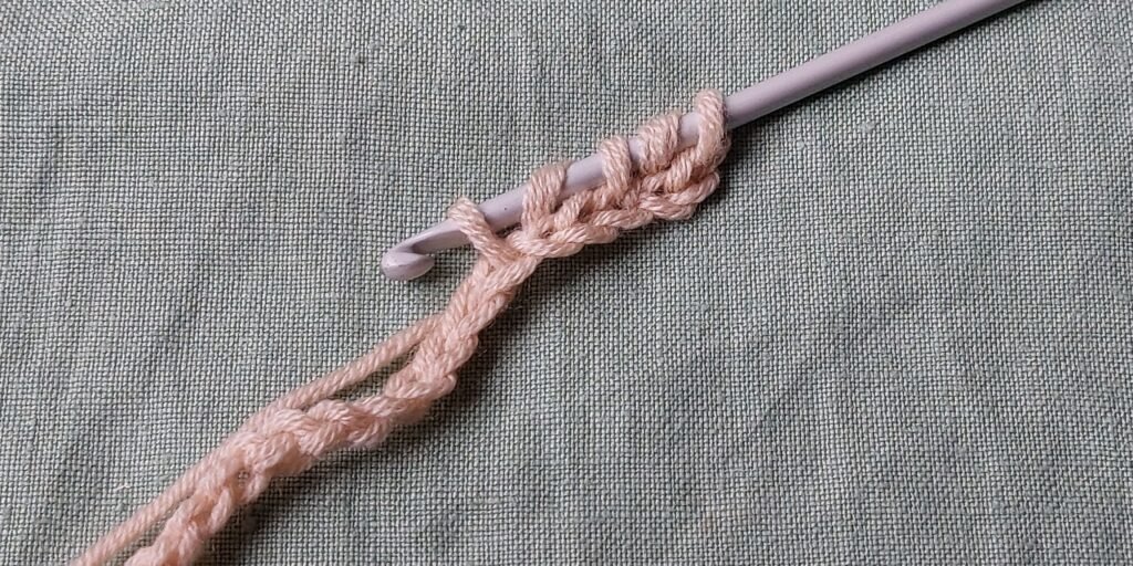 Repeat: YO, skip 2 loops, pull through the third loop (5 loops on the hook)