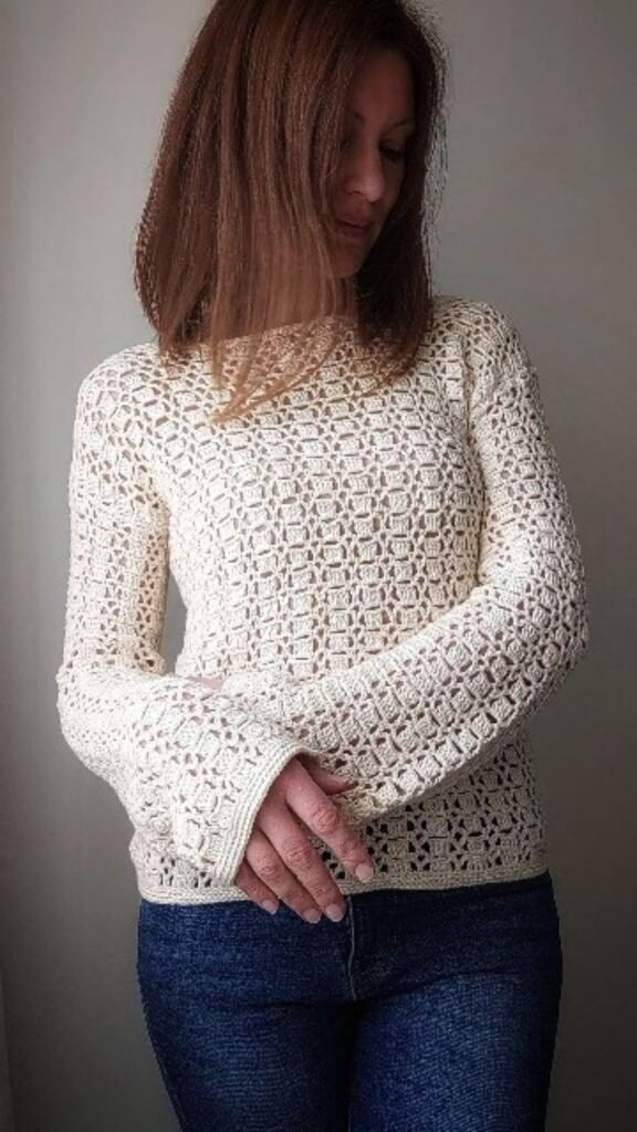 Handmade boho chic crochet sweater in cream color,modeled outdoors.