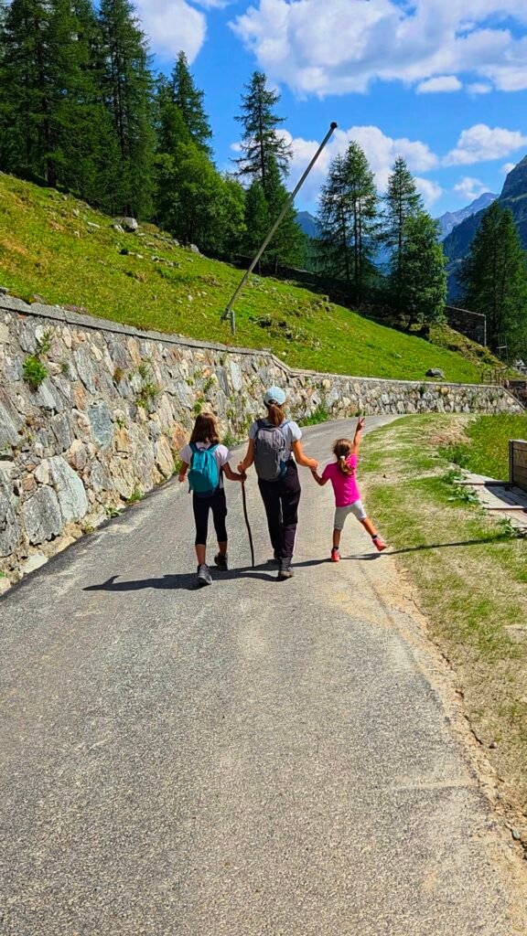 Mother walking with her two daughters along a peaceful mountain road in a valley