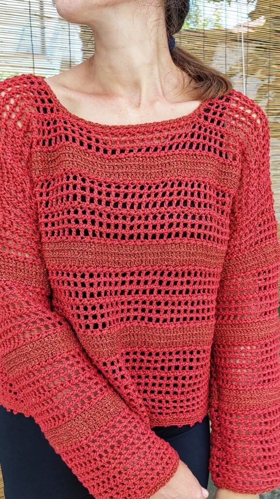 Woman wearing the Easy Stripe crochet sweater during a peaceful walk in nature
