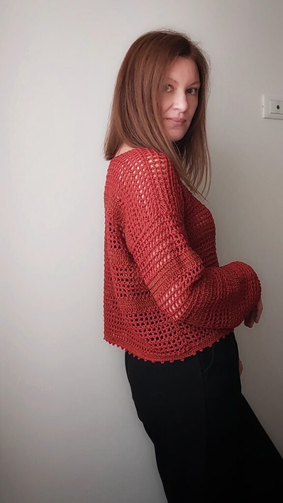 Detail of airy eyelet stripes on a handmade crochet sweater using Tunisian crochet