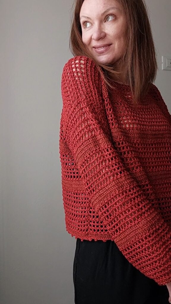 Handmade crochet sweater with openwork stripes in natural yarn, displayed on a model wearing it with a relaxed, minimalist look.