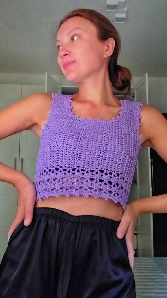 Close-up of a lavender crochet crop top with shell border and ribbed texture
