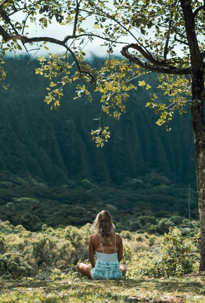 Young woman practicing yoga outdoors with a stunning landscape in the background