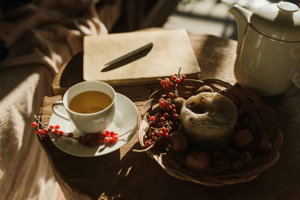 White porcelain teapot on a table, surrounded by morning breakfast items.