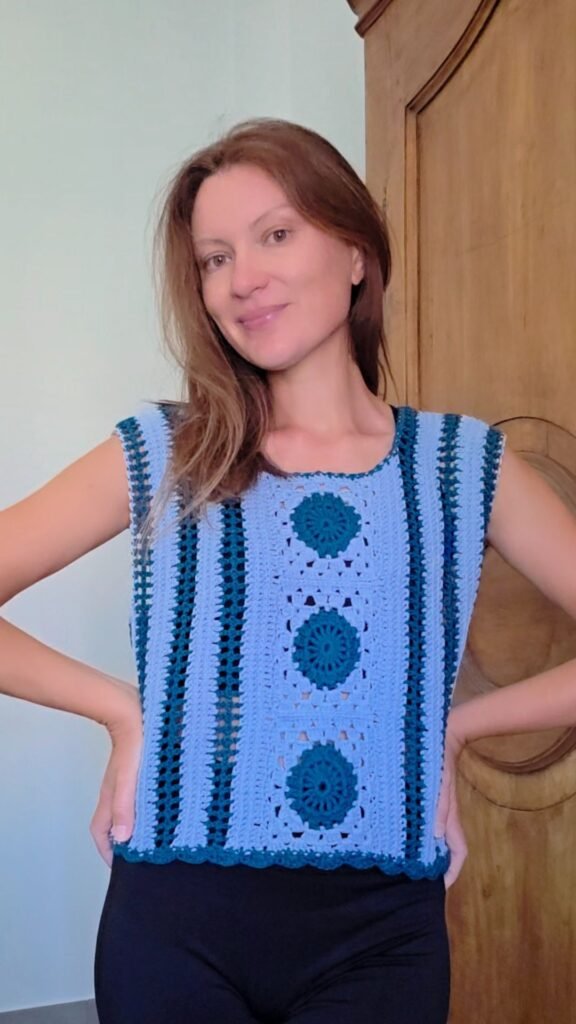 Mary wearing the handmade Serenity Square Top, crocheted with floral square motifs and mesh stitches.