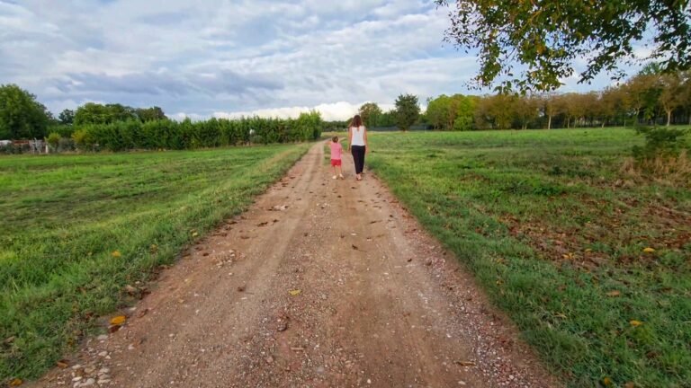Mom and young daughter walking in the countryside after the rain