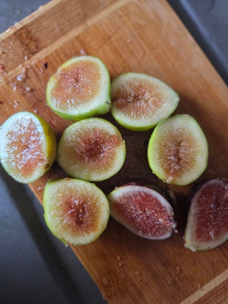 Fresh figs sliced on a wooden board, ready for homemade jam.