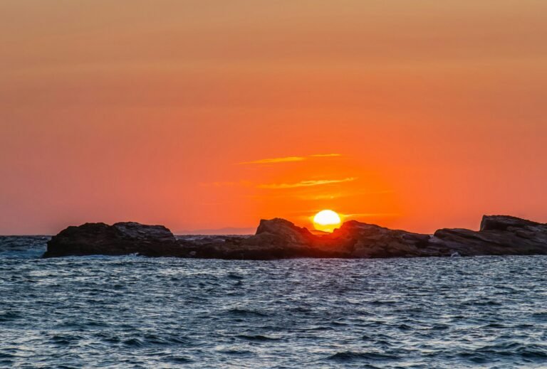 Sunset over the sea with warm colors reflecting on the waves.