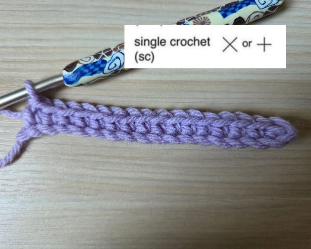 Crochet foundation chain with first row of single crochet stitches and chart symbol .